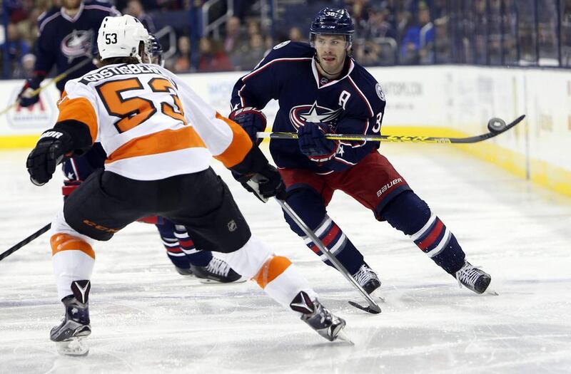 Columbus Blue Jackets’ Boone Jenner, right, carries the puck over the blue line as Philadelphia Flyers’ Shayne Gostisbehere defends during the second period of an NHL hockey game, in Columbus, Ohio. Jay LaPrete / AP