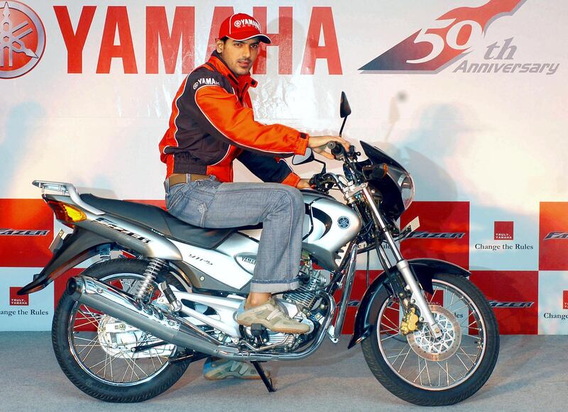 Indian model and Bollywood actor John Abraham,  poses with the new Fazer motorbike at a press conference in New Delhi, 10 June 2005. The new Fazer comes in 2 variants, the Fazer DX and the Fazer LX with a 125cc, 4 stroke engine, counter balancer engine and is priced at INR 42,990( USD 987) and INR 47990 (USD 1102).  AFP PHOTO/ Manan VATSYAYANA (Photo by MANAN VATSYAYANA / AFP)