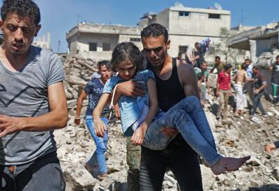 TOPSHOT - A man carries a child rescued from rubble after Syrian regime and Russian air strikes in the rebel-held town of Nawa, about 30 kilometres north of Daraa in southern Syria on June 26, 2018. Syria's army launched an assault on the flashpoint southern city of Daraa Tuesday, state media said, after a week of deadly bombardment on the nearby countryside caused mass displacement. / AFP / Ahmad al-Msalam
