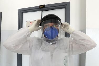 Abir Mdini, a doctor at Tunisia’s emergency medical aid service, or SAMU, dons protective equipment before visiting patients with the coronavirus in Tunis. EPA