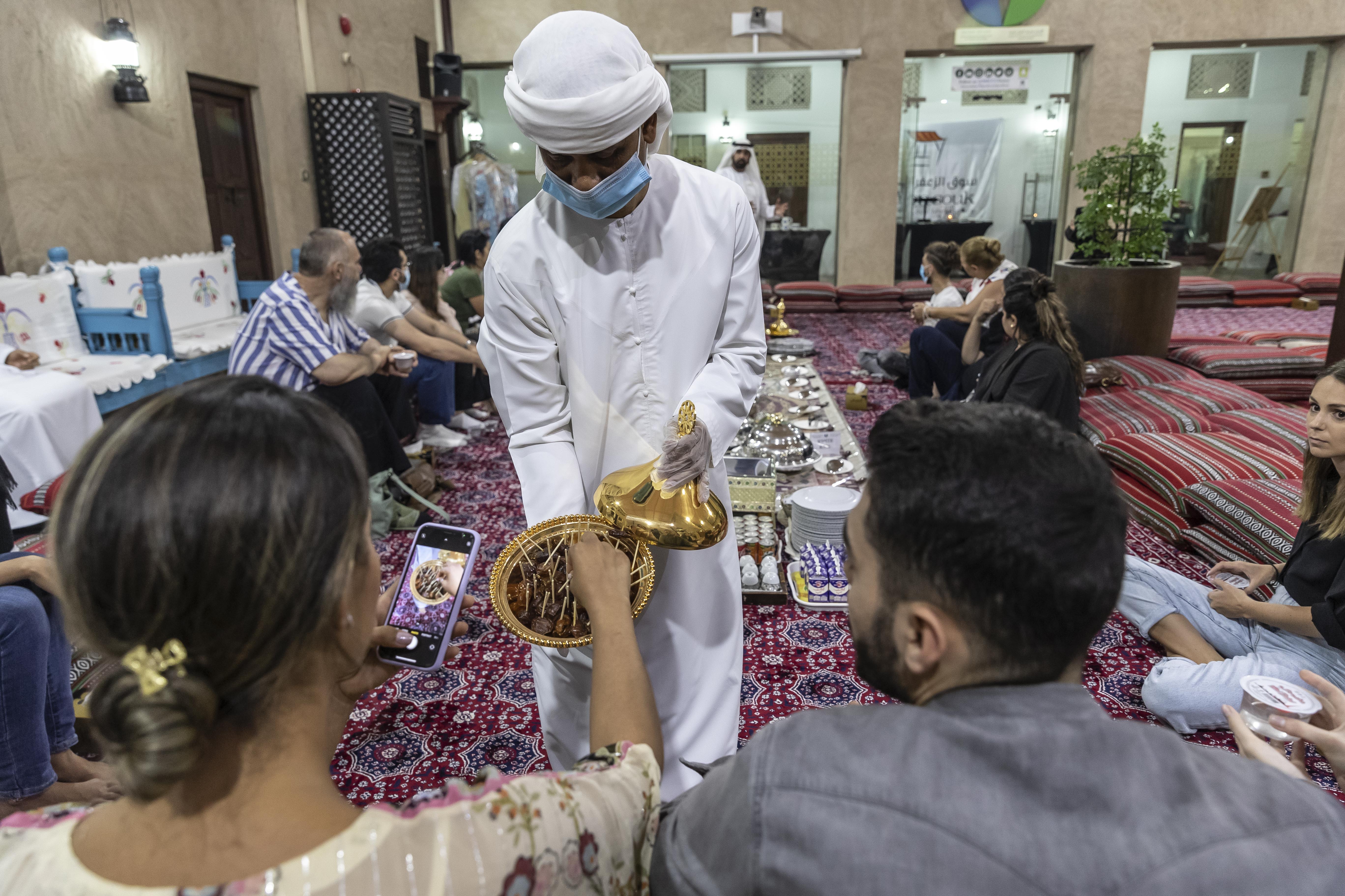 A member of the Sheikh Mohammed bin Rashid Al Maktoum Centre for Cultural Understanding serves visitors dates to break fast with. All photos: Antonie Robertson / The National
