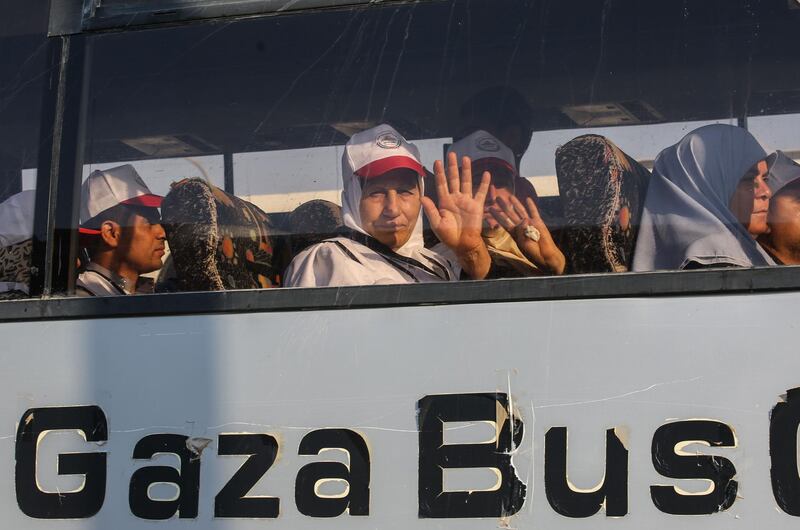 Palestinian pilgrims wave to their relatives as they sit in a bus at the Rafah border crossing.  AFP