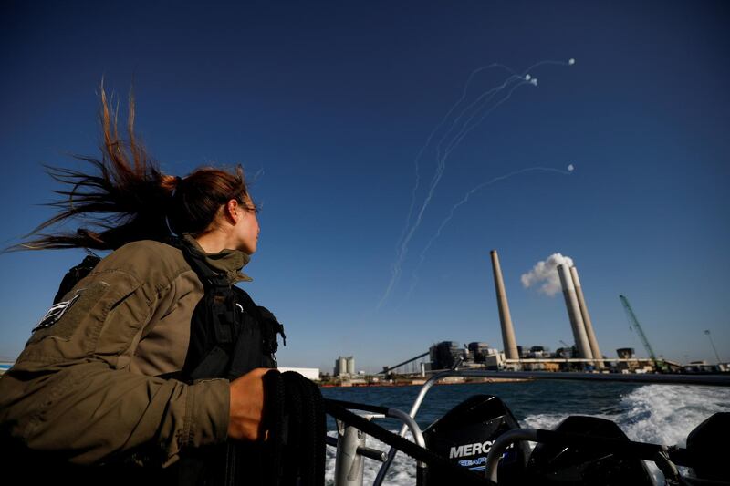 An Israeli soldier watches Israel's Iron Dome anti-missile system intercept rockets launched from the Gaza Strip towards Israel, as she patrols the Mediterranean Sea off the southern Israeli coast in a naval boat. Reuters