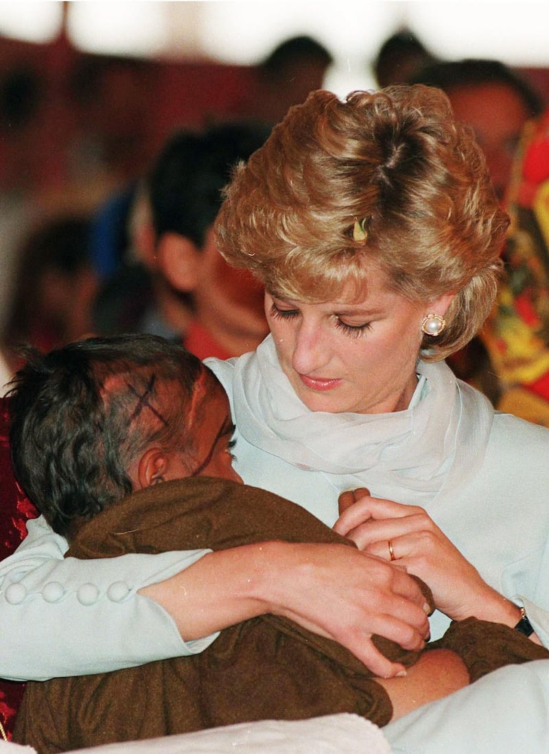 LAHORE, PAKISTAN - FEBRUARY 22: Diana, Princess of Wales, wearing a pale blue shalwar kameez, cradles a young Cancer patient in her arms during a visit to Shaukat Khanum Hospital on February 22, 1996 in Lahore, Pakistan.  (Photo by Anwar Hussein/WireImage)