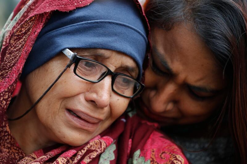 A woman who lost her husband during Friday's mass shootings cries outside an information center for families, Saturday, March 16, 2019, in Christchurch, New Zealand. The white supremacist gunman appeared in court Saturday charged with murder in the mosque assaults that killed at least 49 people and led to the prime minister to call for a tightening of national gun laws. (AP Photo/Vincent Thian)