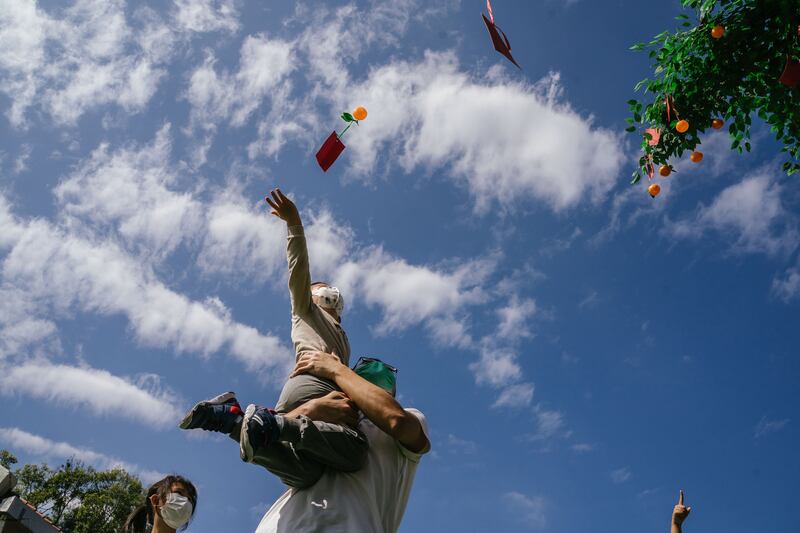 A child throws red joss paper with new year wishes on to the Lam Tsuen Wishing Tree in Hong Kong. Getty