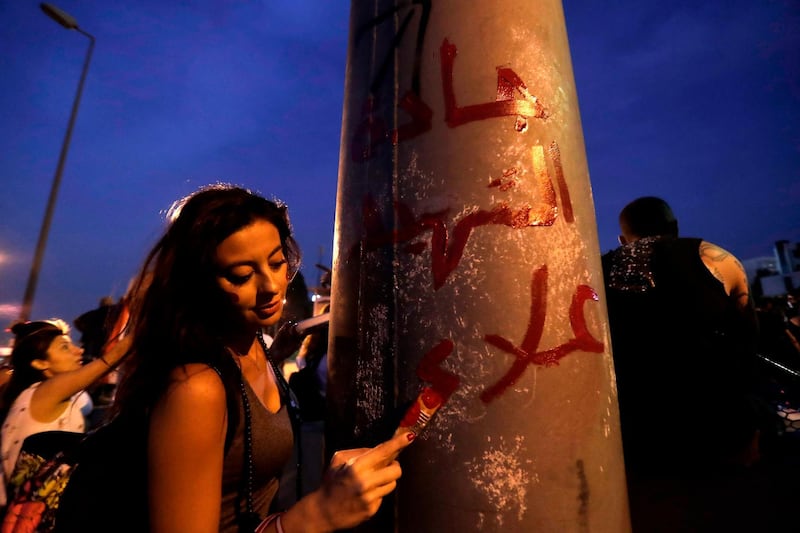 A Lebanese demonstrator writes "Alaa Abou Fakhr Boulevard" during a gathering on the road leading to the Presidential Palace in Baabda, on the eastern outskirts of Beirut on November 13, 2019, nearly a month into an unprecedented anti-graft street movement. Alaa Abou Fakhr died of gunshot wounds overnight after the army opened fire to disperse protesters south of the capital, in the second such death since the start of the largely peaceful protests. / AFP / ANWAR AMRO
