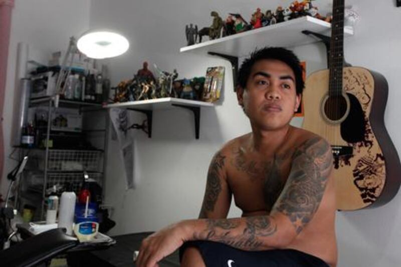 Lawrence Talento, 24, displays his collection of 13 tattoos and says he plans to add more images to his extensive body art. Jeffrey E Biteng / The National