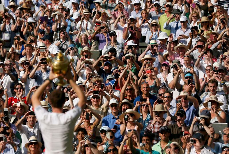 Andy Murray of Britain holds the winners trophy up to the spectators after defeating Novak Djokovic of Serbia in their men's singles final tennis match at the Wimbledon Tennis Championships, in London July 7, 2013.              REUTERS/Stefan Wermuth (BRITAIN  - Tags: SPORT TENNIS)   *** Local Caption ***  WIM151_TENNIS-WIMBL_0707_11.JPG