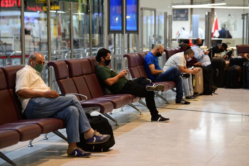 Passengers, wearing face masks waiting in Baghdad International Airport on its reopening day in Baghdad, Iraq.  EOA