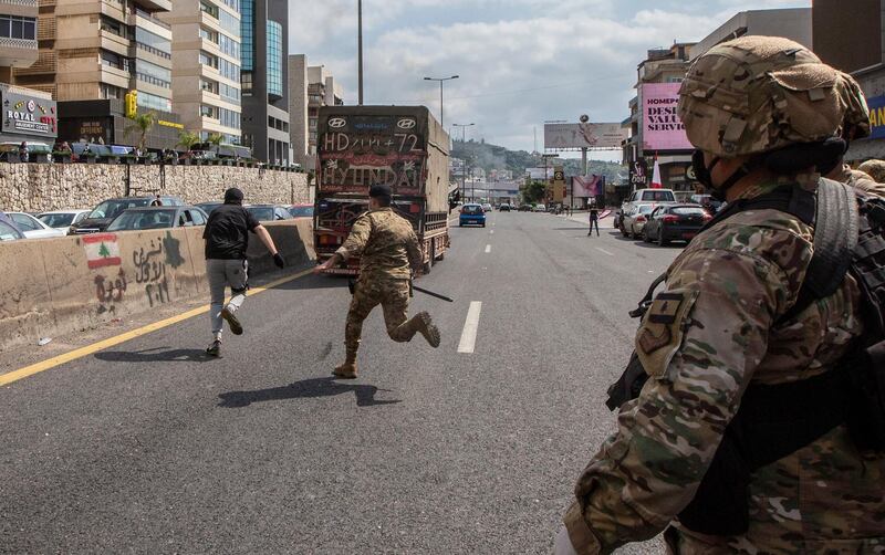 Lebanese army soldiers scuffle with supporters of Lebanese Christians parties where they try to open the Northern Highway during a protest against the collapsing Lebanese pound currency and the price hikes of goods, in Al-Zouk area, northern Beirut, Lebanon.  EPA