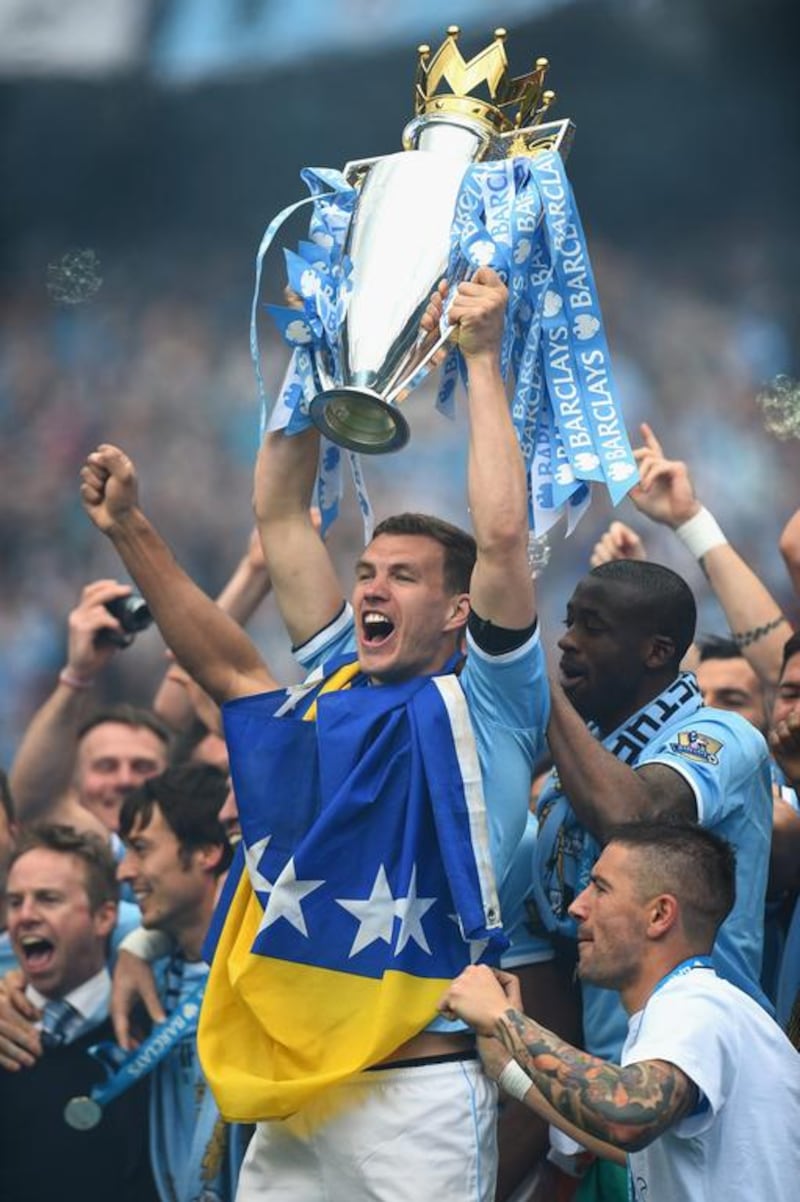 Edin Dzeko of Manchester City lifts the Premier League trophy at the end of their Premier League match against West Ham United at the Etihad Stadium on May 11, 2014 in Manchester, England. Shaun Botterill/Getty Images