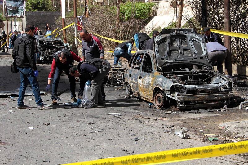 Egyptian forensics check a destroyed vehicle at the site of a bomb attack in the northern port city of Alexandria, which hit a convoy of the city's security chief, on March 24, 2018. / AFP PHOTO / STRINGER