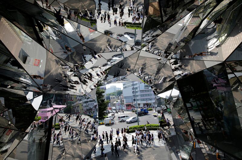 Passers-by are reflected in mirrors in a mall at Harajuku shopping district in Tokyo. Shizuo Kambayashi / AP Photo