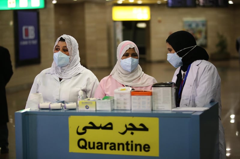 Airport officials wait to screen the temperature of passengers in order to detect a possible coronavirus infection, at Cairo International Airport, in Cairo, Egypt.  EPA