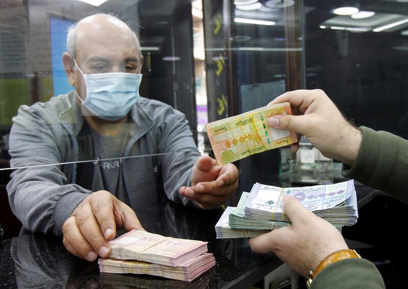 A man wearing a face mask takes Lebanese pound banknotes at a currency exchange shop in Beirut, Lebanon April 24, 2020. REUTERS/Mohamed Azakir