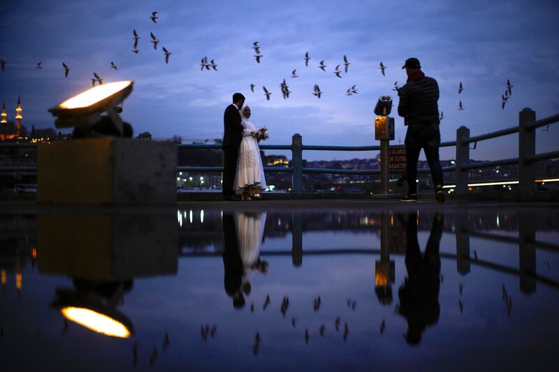 A young couple pose during a video and photography session at Galata bridge in Istanbul. AP