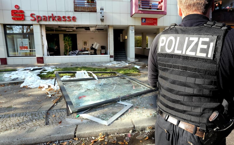 Policemen search for traces in front of a Sparkasse branch in Berlin, Germany, 10 October 2014. Unknowns triggered an exploison in the branch and cleared several lockers. Photo: Wolfgang Kumm/dpa | usage worldwide   (Photo by Wolfgang Kumm/picture alliance via Getty Images)