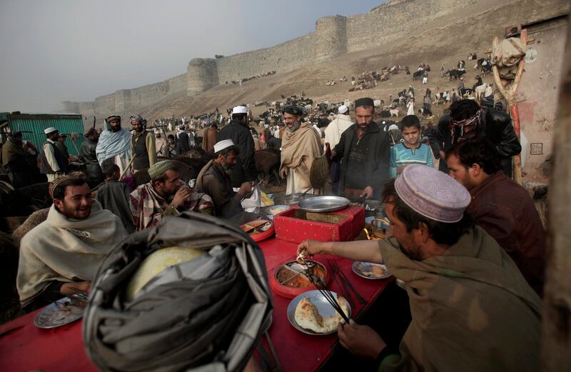 Afghan livestock merchants and customers have their breakfast at an open market for the upcoming Eid-al-Adha festival, in an open market in Kabul, Afghanistan, Friday, Nov. 4, 2011. (AP Photo/Muhammed Muheisen) *** Local Caption ***  Afghanistan Eid-al-Adha.JPEG-05ddd.jpg