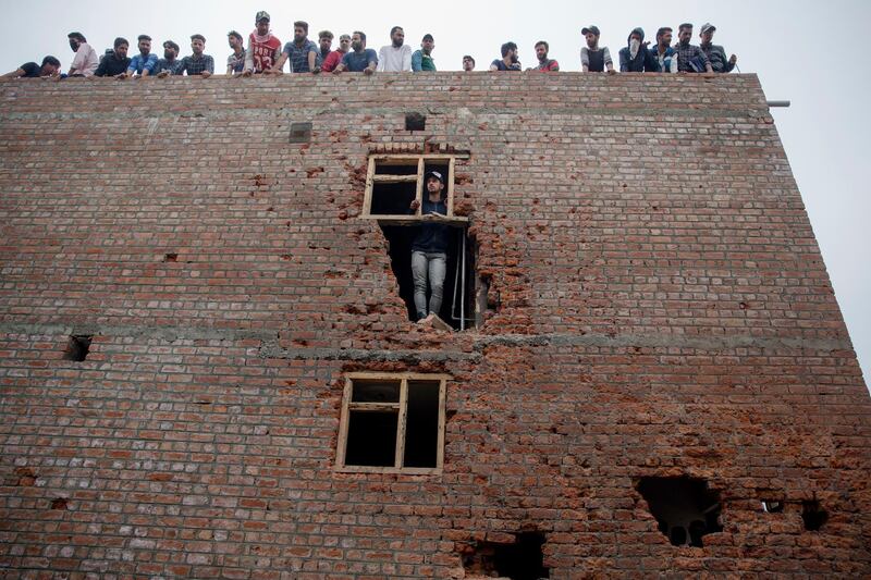Kashmiri men inspect a damaged house where suspected rebels were holed up, after a gun battle in Srinagar, Indian controlled Kashmir. Dar Yasin / AP Photo