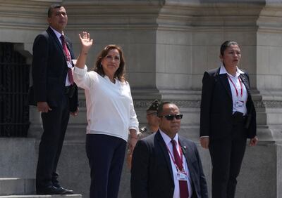 Surrounded by security, Peru's President Dina Boluarte waves to the press outside the government palace. AP Photo