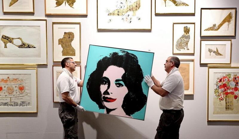 Two men hang the portrait of Warhol’s Liz Taylor at the Museo Fondazione Roma in Rome, Italy. (Alessandro di Meo / EPA/ 16 April, 2014)