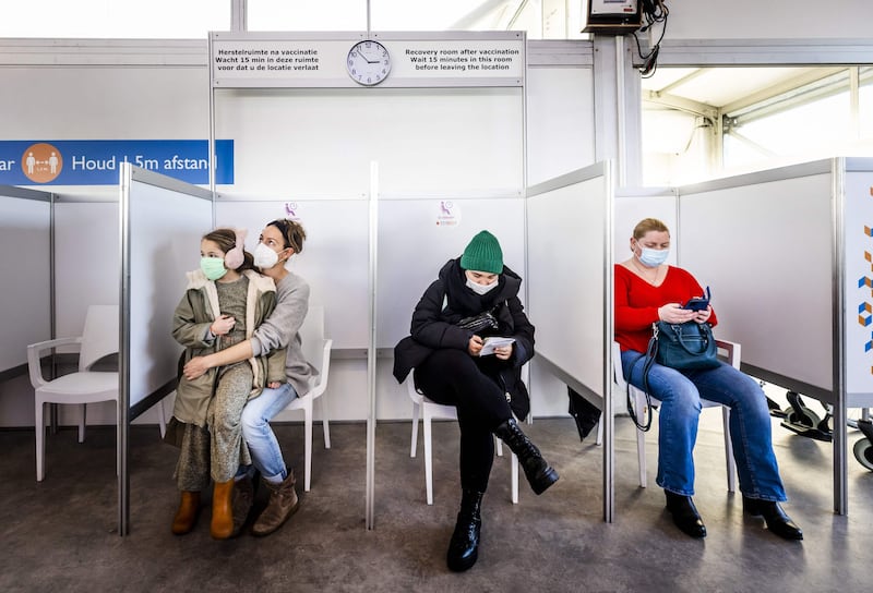 People sit in a waiting area in case of an immediate reaction after receiving booster shots at a Covid-19 vaccination centre set up in Schiphol Airport in Amsterdam. AFP