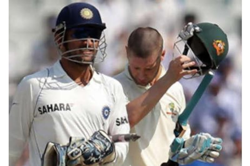 The India captain Mahendra Singh Dhoni, left, walks past Australia's Michael Clarke after defeating Australia on the fifth day of the second Test to take a 1-0 lead in the series.