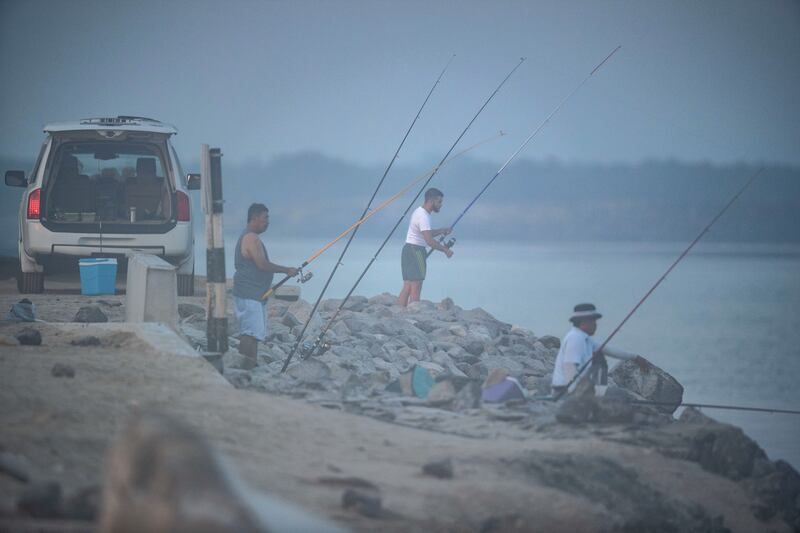 Anglers patiently wait for a catch at the Yas Island Iron Bridge area on a foggy morning.
