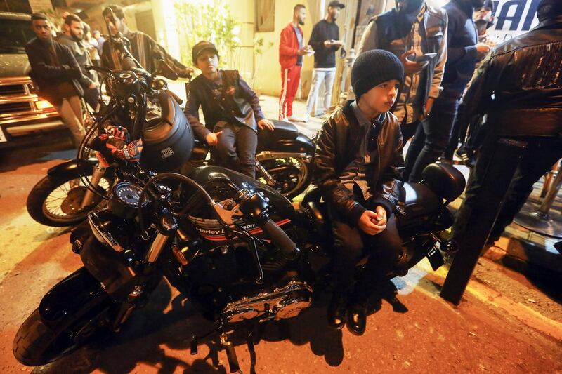 Libyan youths sit on motorcycles belonging to a Libyan biker club outside a cafe in the capital Tripoli.   AFP