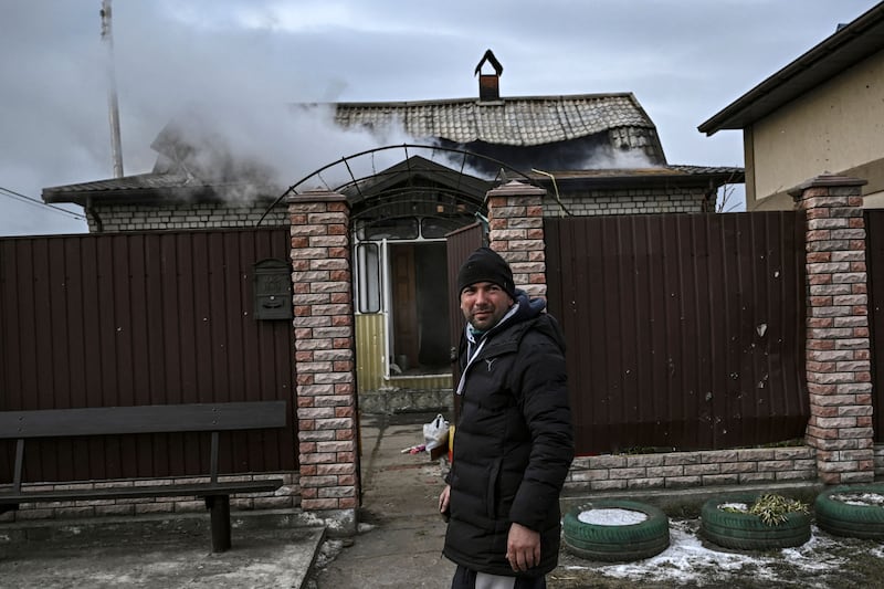 A man walks past a shelled house at the village of Velyka Dymerka, east of Kyiv. AFP