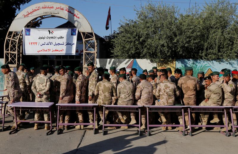 Members of Iraqi security forces outside a polling station in Mosul wait to cast their vote. Reuters