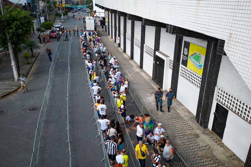 Soccer fans line up to attend Pele's wake. AP 