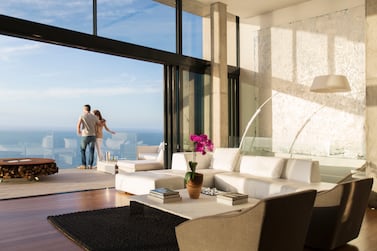 Couple standing looking out at their view from their expensive apartment. Photo: Getty Images