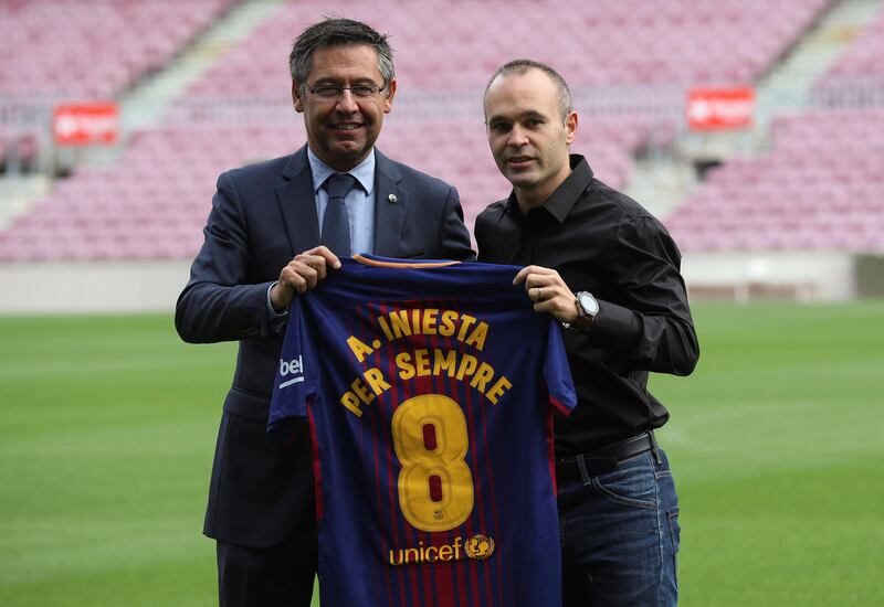 Barcelona captain Andres Iniesta, right, holds up a jersey with Barcelona president Josep Maria Bartomeu after announcing his new 'lifetime' contract. Albert Gea / Reuters