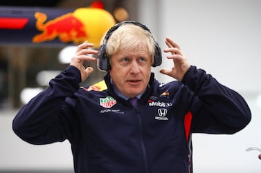 Britain's Prime Minister Boris Johnson adjusts his protective headphones during a visit at Red Bull Racing in Milton Keynes, Britain December 4, 2019 Reuters