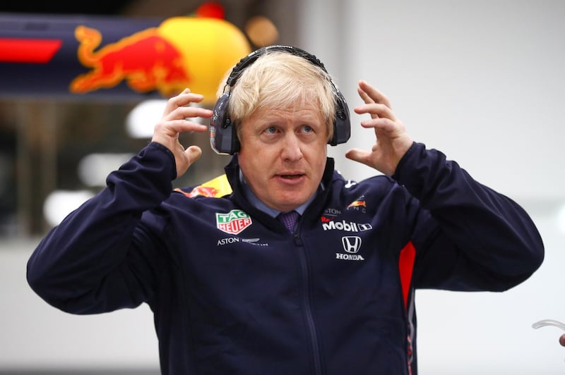 Britain's Prime Minister Boris Johnson adjusts his protective headphones during a visit at Red Bull Racing in Milton Keynes, Britain December 4, 2019. REUTERS/Hannah McKay/Pool     TPX IMAGES OF THE DAY