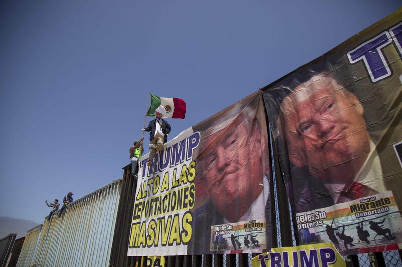 Members of the "Angels without Borders" organisation hold a protest against the anti-immigrant policy of US President Donald Trump next to the metal fence in Playas de Tijuana, in the Mexico-US border. Omar Martinez / AFP Photo