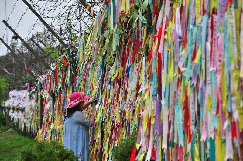 A visitor looks at ribbons wishing for peace and reunification of the two Koreas on a military fence at Imjingak peace park, near the Demilitarized zone (DMZ) dividing South and North Korea in Paju.  AFP
