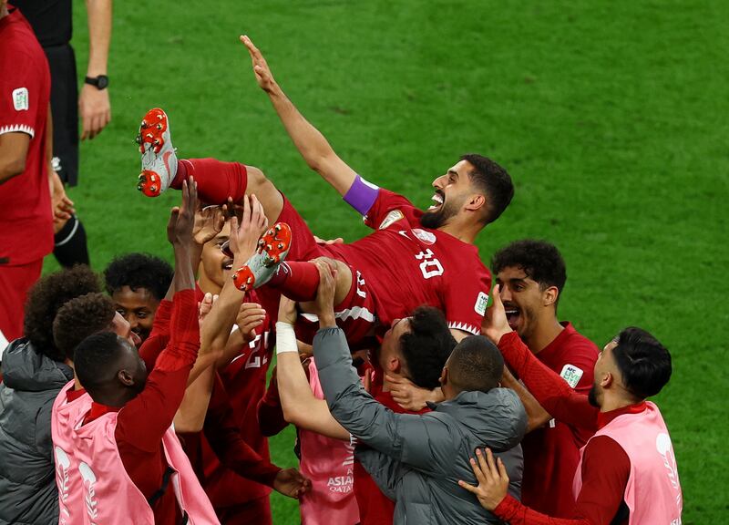 Qatar players lift Hassan Al Haydos in the air to celebrate his brilliant goal against China. Reuters