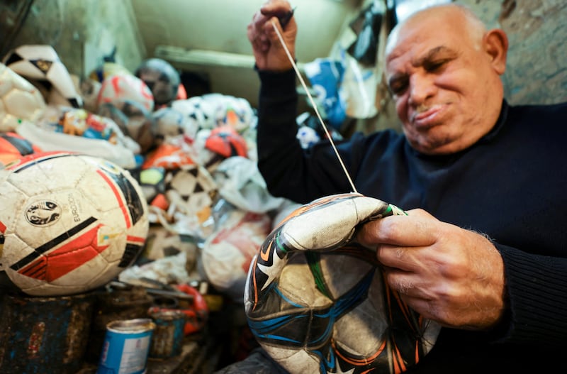 Mostafa Mahmoud, 68, stitches a football at his shop in Cairo, Egypt. All photos: Reuters