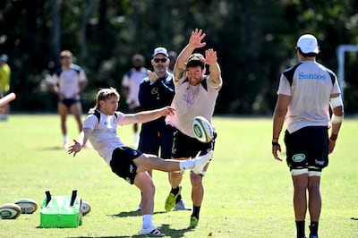 Tate McDermott kicks the ball as Cadeyrn Neville attempts to charge it down during an Australian Wallabies training session. Getty Images