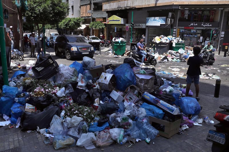A road in Beirut is partially blocked with rubbish and bins on July 14, 2020 in protest against a halt in collections by the waste management company responsible for the Lebanese capital. AP Photo