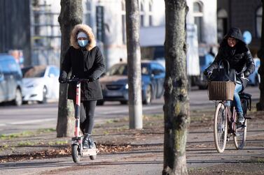 A woman rides an electric scooter wearing a protective mask, amid the continuous spread of the coronavirus disease (COVID-19) pandemic, along Standvagen in Stockholm, Sweden, November 20, 2020. TT News Agency/Fredrik Sandberg via REUTERS ATTENTION EDITORS - THIS IMAGE WAS PROVIDED BY A THIRD PARTY. SWEDEN OUT. NO COMMERCIAL OR EDITORIAL SALES IN SWEDEN.