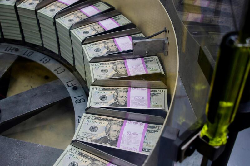Packs of freshly printed 20 USD notes are processed for bundling and packaging at the US Treasury's Bureau of Engraving and Printing in Washington, DC July 20, 2018. The dollar slid against the euro and pound on Friday, July 20, 2018, as US President Donald Trump adopted an aggressive posture on trade and foreign exchange, stoking talk of a currency war in addition to a trade war. / AFP / Eva HAMBACH
