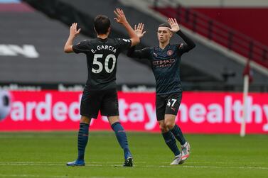 Manchester City's Phil Foden, right, celebrates with Garcia after scoring his side's opening goal during the English Premier League soccer match between West Ham and Manchester City, at the London Olympic Stadium Saturday, Oct. 24, 2020. (Paul Childs, Pool via AP)