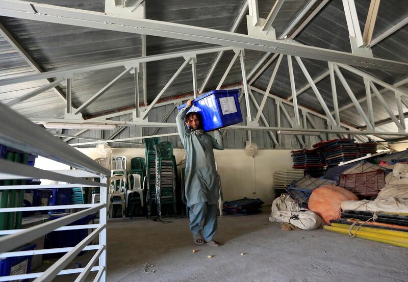 An election commission worker carries a ballot box and election material to send to the polling stations at a warehouse in Jalalabad city. Reuters