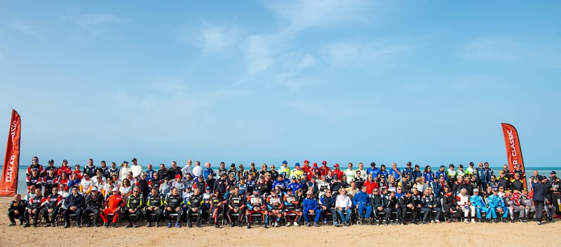 Competitors in the Dakar Classic Rally 2023 pose for a group photo on the beach at Sea Camp during the prologue.  EPA