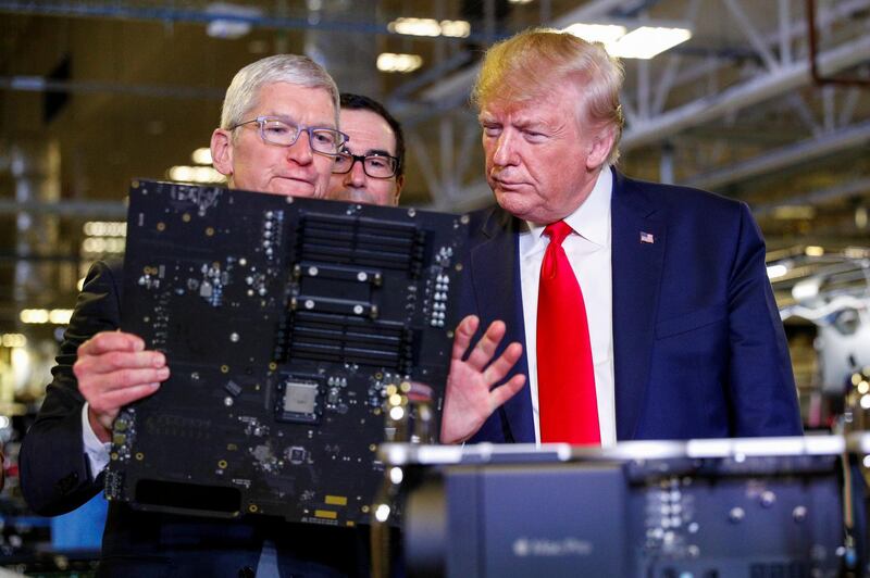 Apple CEO Tim Cook escorts U.S. President Donald Trump as he tours Apple's Mac Pro manufacturing plant with Treasury Secretary Steven Mnuchin looking on. Reuters