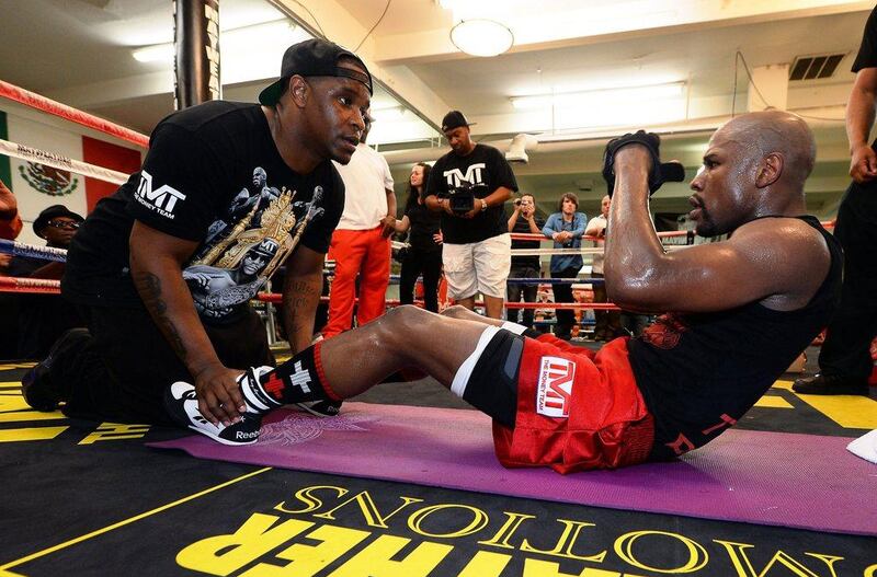 Floyd Mayweather does sit ups with his cousin DeJaun Blake during his Tuesday workout session at Mayweather Boxing Club. Ethan Miller / Getty Images / AFP / April 22, 2014